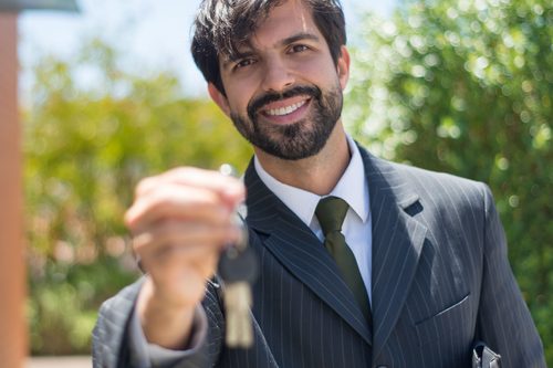 Real estate agent handing over house keys after a purchase