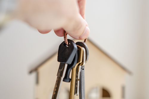 House keys resting beside a small model home